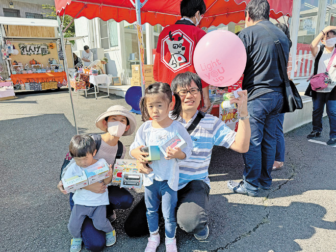 抽選会でプレゼントを手にする家族連れ