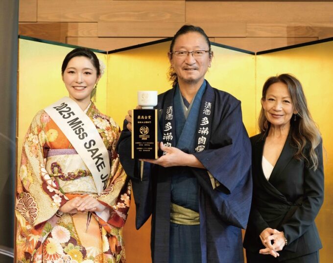 最高金賞の表彰式で八神純子さん（右）からトロフィーを贈られた石川社長