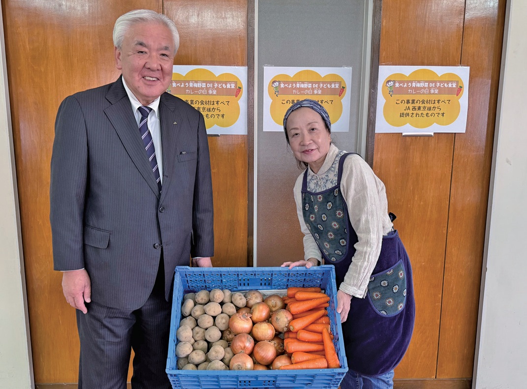 松永組合長（左）からフードバンク青梅の三宅さんに渡された