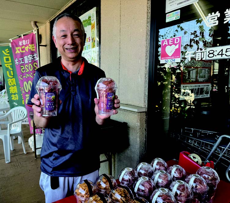 ドラゴンレッドのポテトチップスを持つ荒井さん